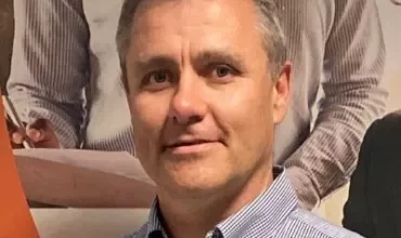 Person smiling in front of office background